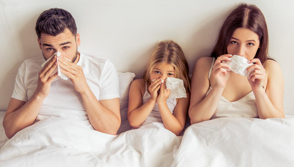 famiglia a letto con il raffreddore